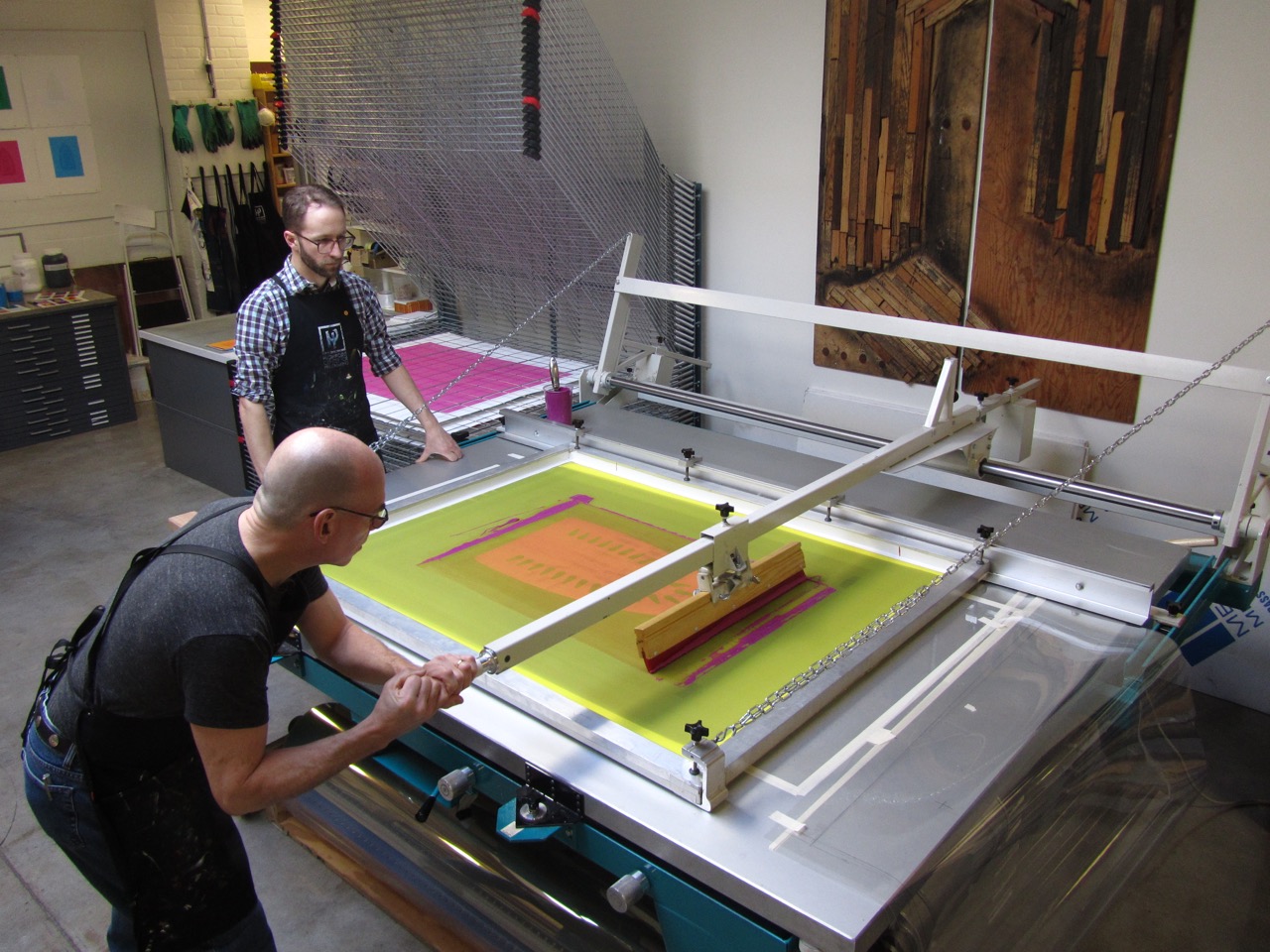 ‘Master Printer Cole Rogers and Senior Printer Zac Adams-Bliss editioning Willie Cole’s large-scale screenprints, 2012. Image Courtesy of Highpoint Editions”