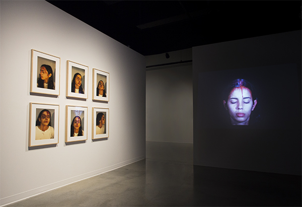 Ana Mendieta Left: Self-Portrait with Blood, 1973/1997, Suite of six color photographs, framed, 20 x 16 in. (50.8 x 40.6 cm) each. Right: Sweating Blood, November 1973, Super 8 film, color, silent, 3 min. 18 sec., Filmwork No. 14. © The Estate of Ana Mendieta Collection, LLC. Courtesy Galerie Lelong, New York. Installation photograph by Amber White.