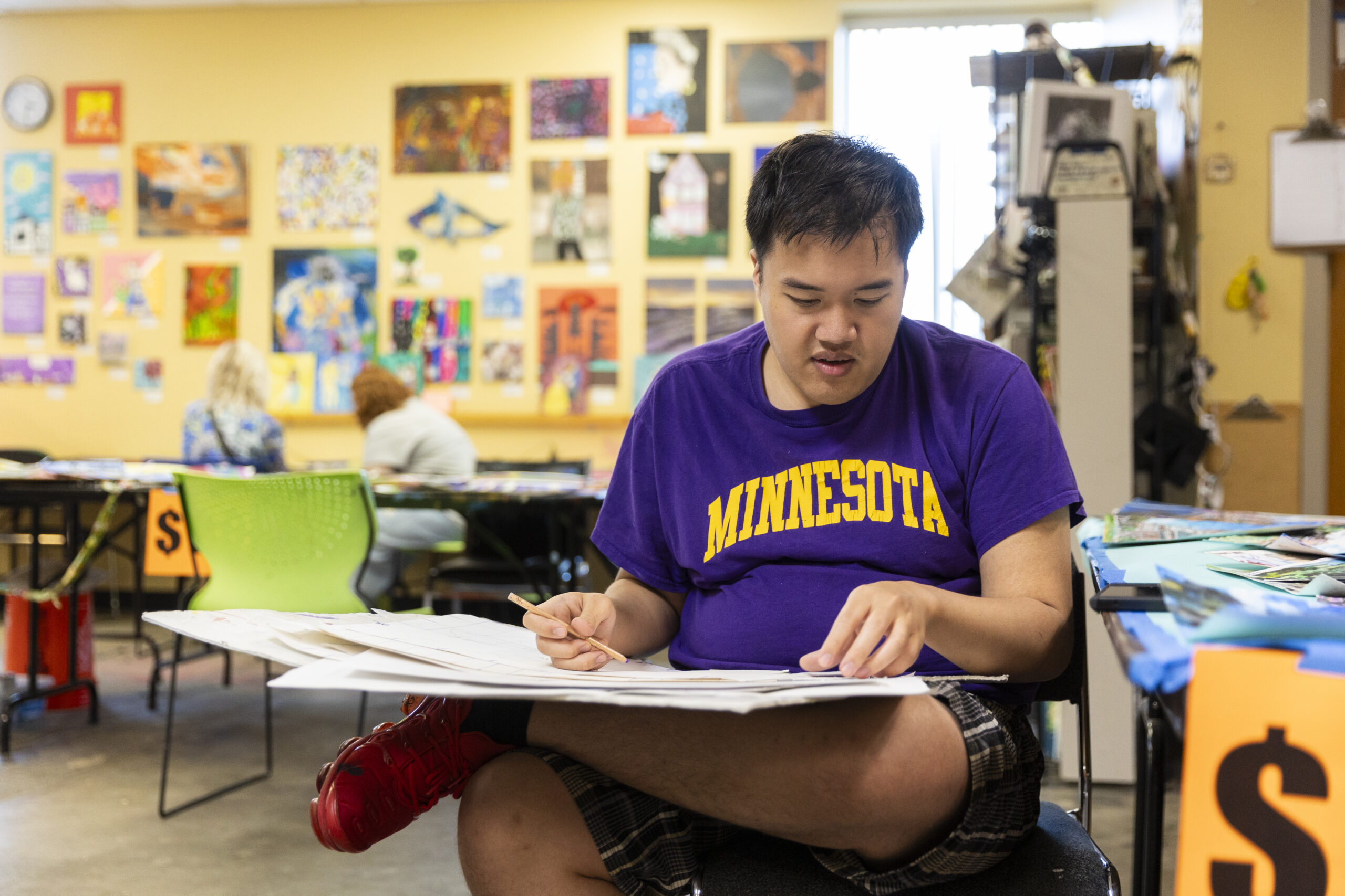 Victor Van, who recently became the first Interact artist to have work acquired by the Walker Art Center, works on a painting in the Interact studio.